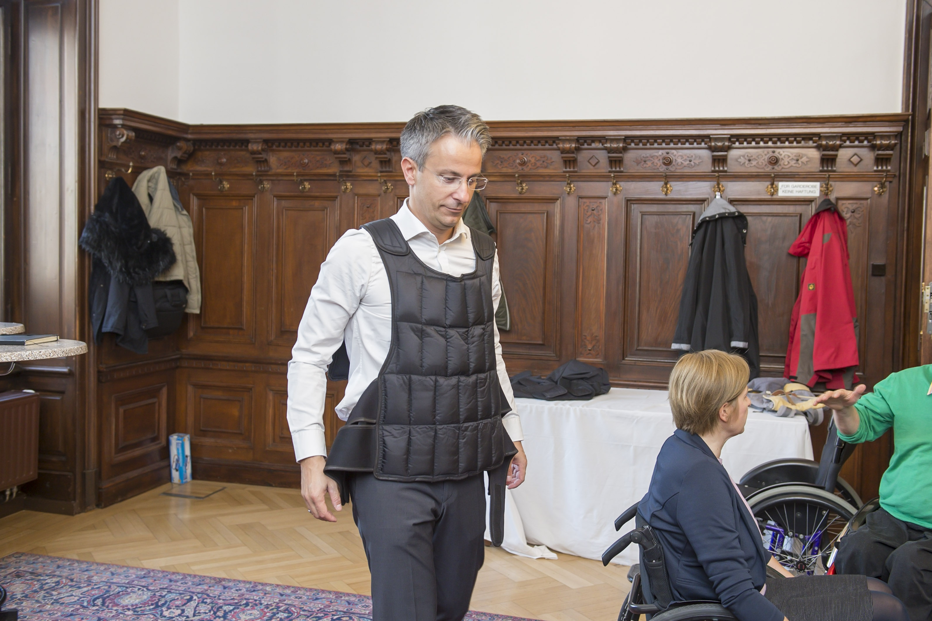 Stadtrat Kurt Hohensinner mit einem Anzug, der mit Gewichten die Bewegungseinschränkungen von alten Menschen nachstellt.