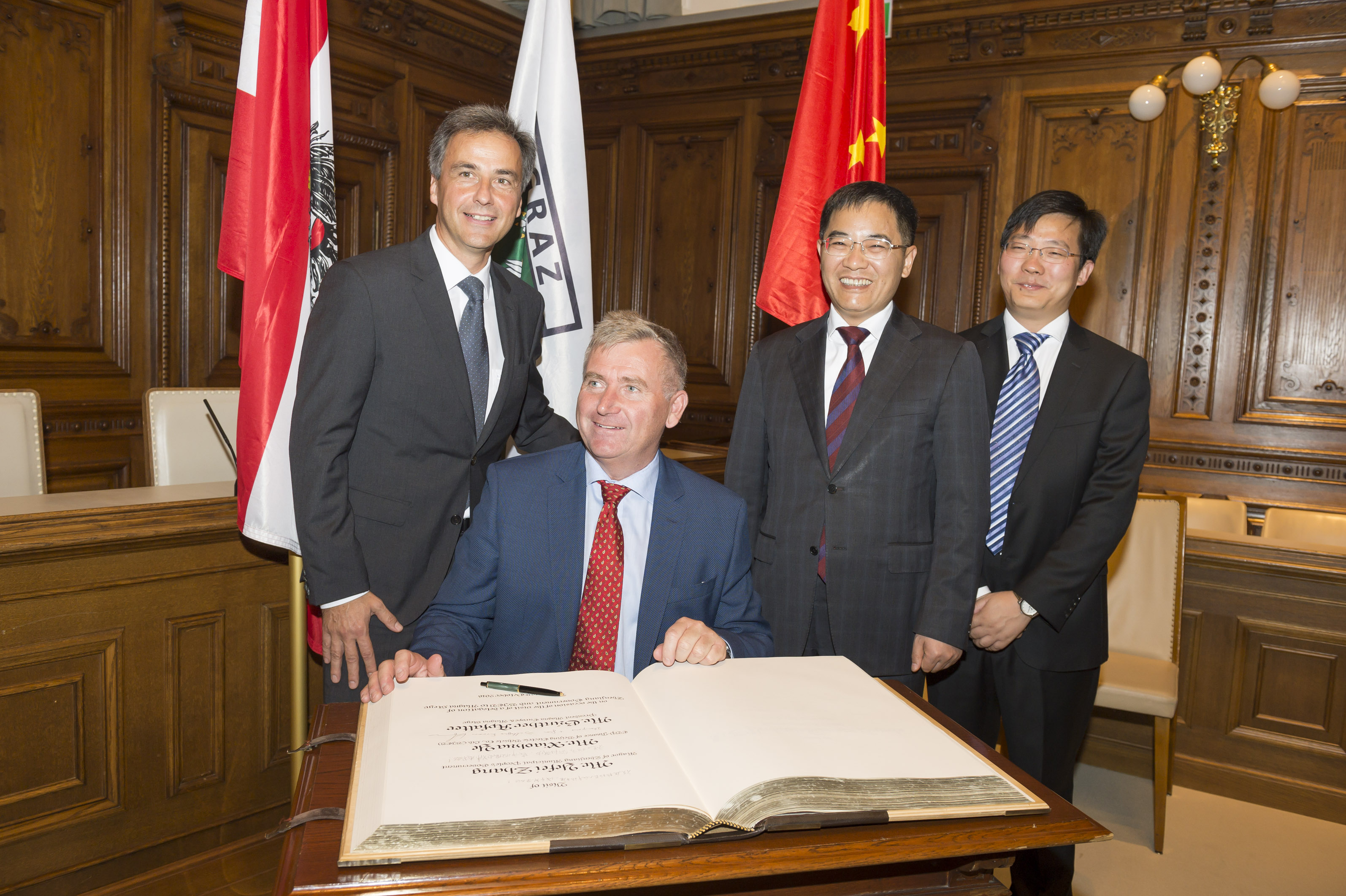 Bürgermeister Nagl mit der Delegation aus Zhenjiang sowie Magna-Präsident Günther Apfalter (sitzend).