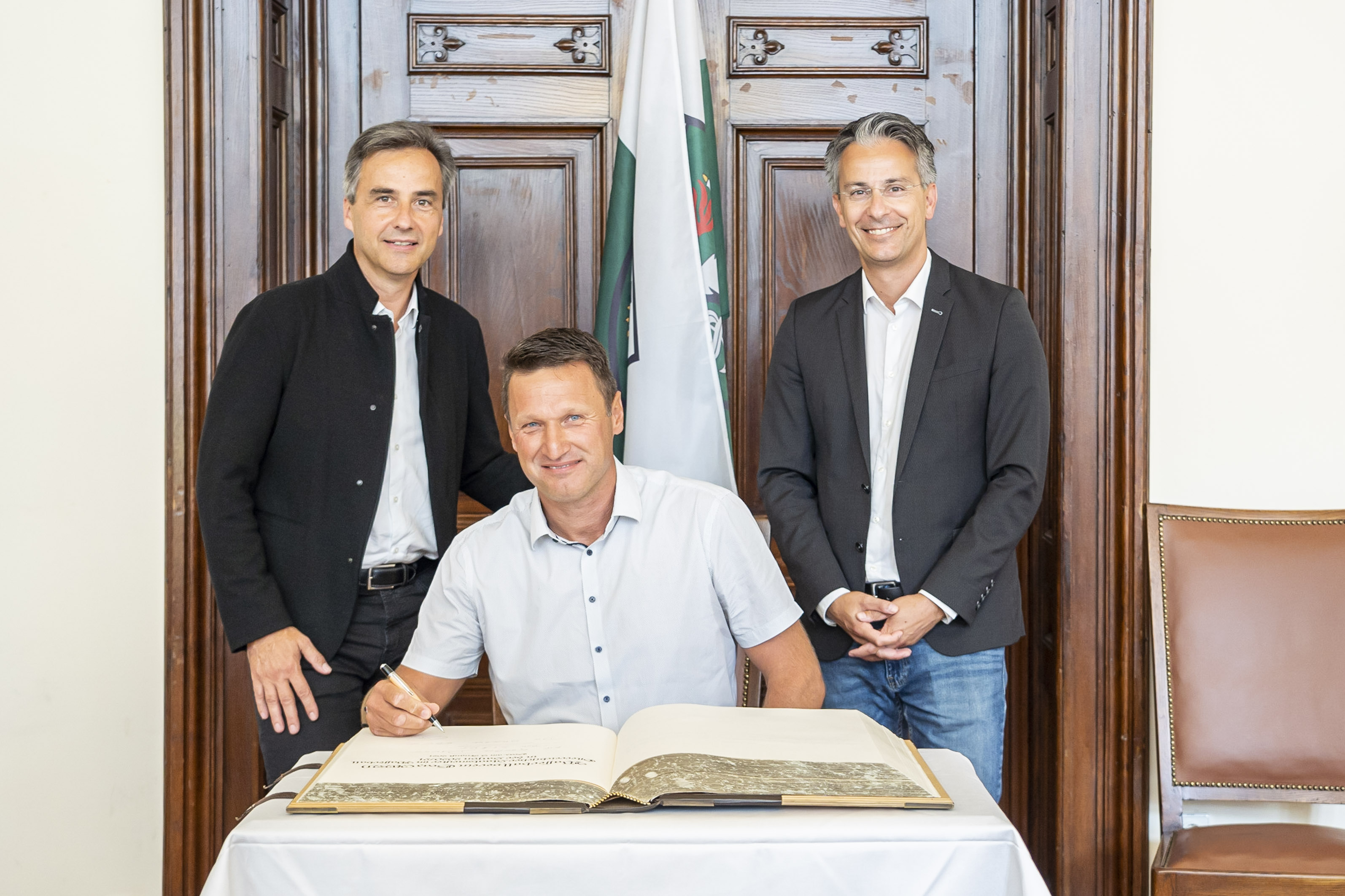 Vereinspräsident Gerd Lang (m.) durfte sich unter den Augen von Bürgermeister Siegfried Nagl (l.) und Sportstadtrat Kurt Hohensinner (r.) im Goldenen Buch verewigen.