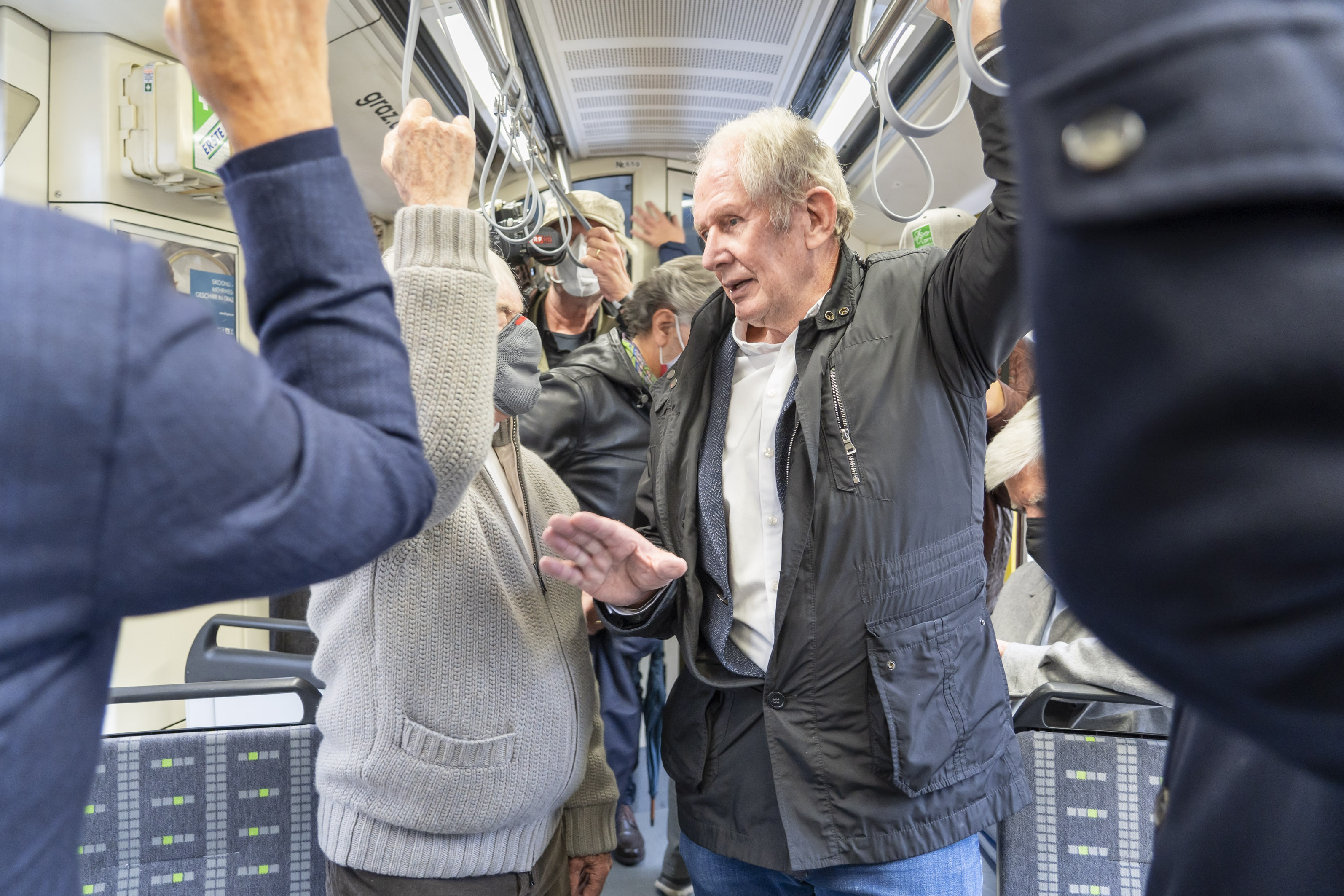 Bernie Ecclestone und Helmut Marko unterhalten sich in der Straßenbahn