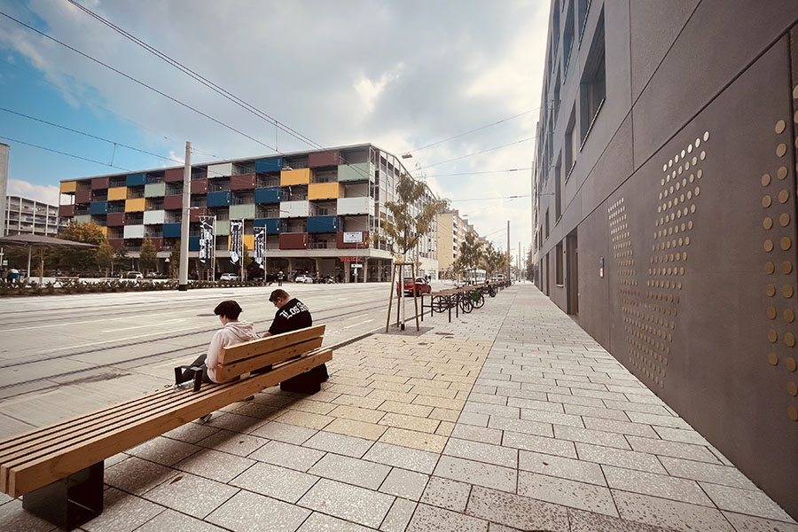 Sitzt, passt, hat Luft: Der öffentliche Raum in der Smart City stimmt sich auf den goldenen Herbst ein. Bänke, Bäume und Radständer sind bereits fest verwurzelt.