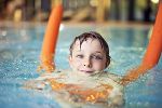 Symbolbild: Kind in Wasser mit Schwimmnudel