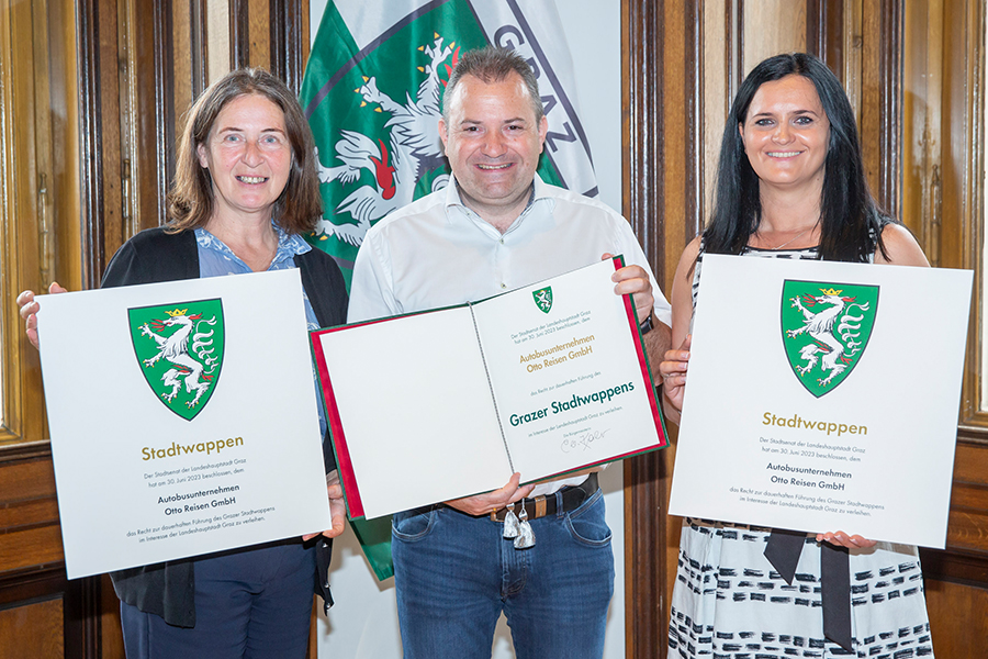 Mit einem Lächeln übergab Bürgermeisterin Elke Kahr (l.) das Stadtwappen an Christian und Kerstin Ziegler von "Otto Reisen". © Stadt Graz/Fischer Mit einem Lächeln übergab Bürgermeisterin Elke Kahr (l.) das Stadtwappen an Christian und Kerstin Ziegler von "Otto Reisen".