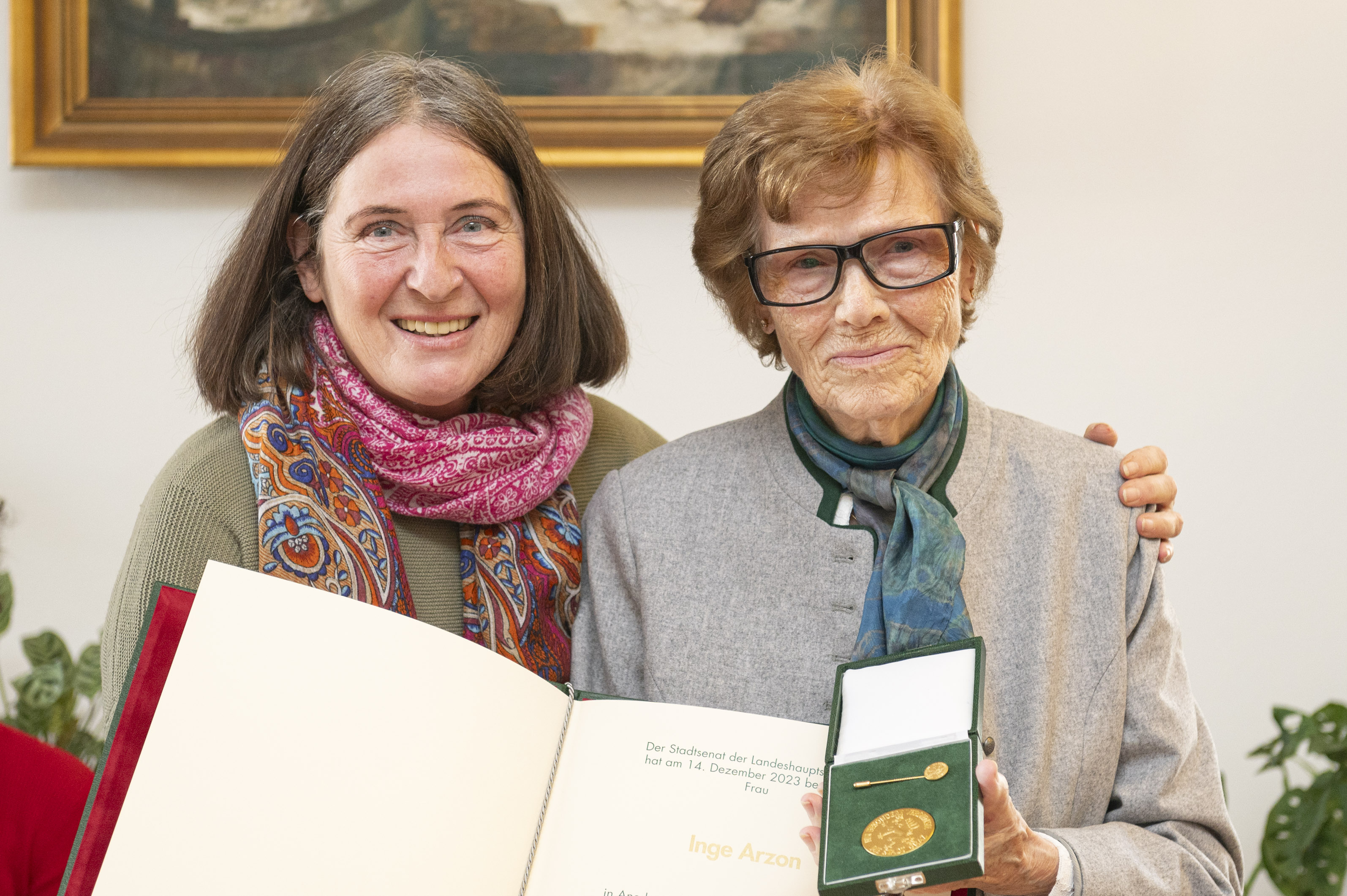 Inge Arzon mit dem Goldenen Ehrenzeichen der Stadt Graz sowie der dazugehörigen Urkunde.