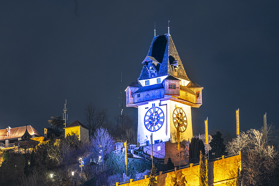 Zwei Jahre Ukrainekrieg: Der Uhrturm leuchtet in den Farben Blau und Gelb.