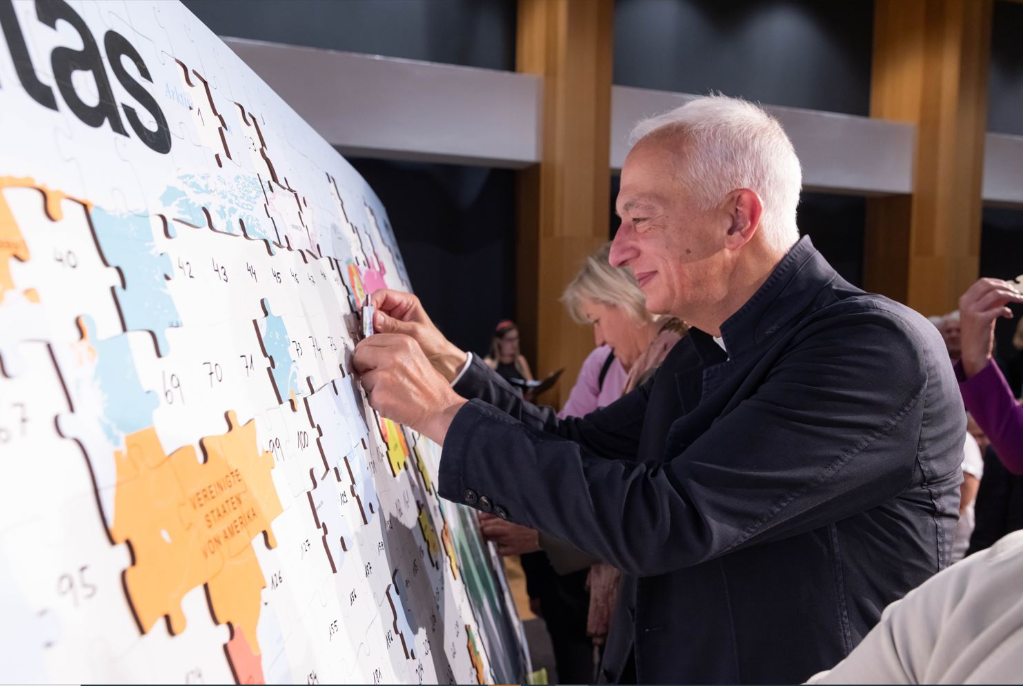 Jeder Gast sorgte mit einem eigenen Puzzleteil dafür, dass das Bild der Caritas zu einem Großen Ganzen wurde. Vorne: Michael Landau, Caritas-Präsident Europa