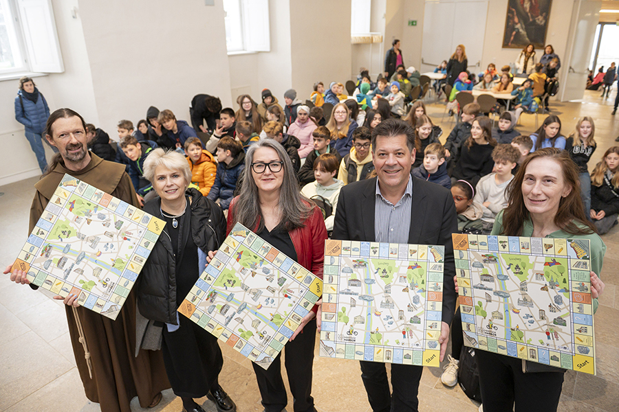 Das Grazer Welterbe – zum spielerischen Erfahren, v. l.: Pater Andreas, Elke Knoll, Gertraud Strempfl-Ledl, Bertram Werle, Marion Starzacher mit Schüler:innen der AHS Reininghaus