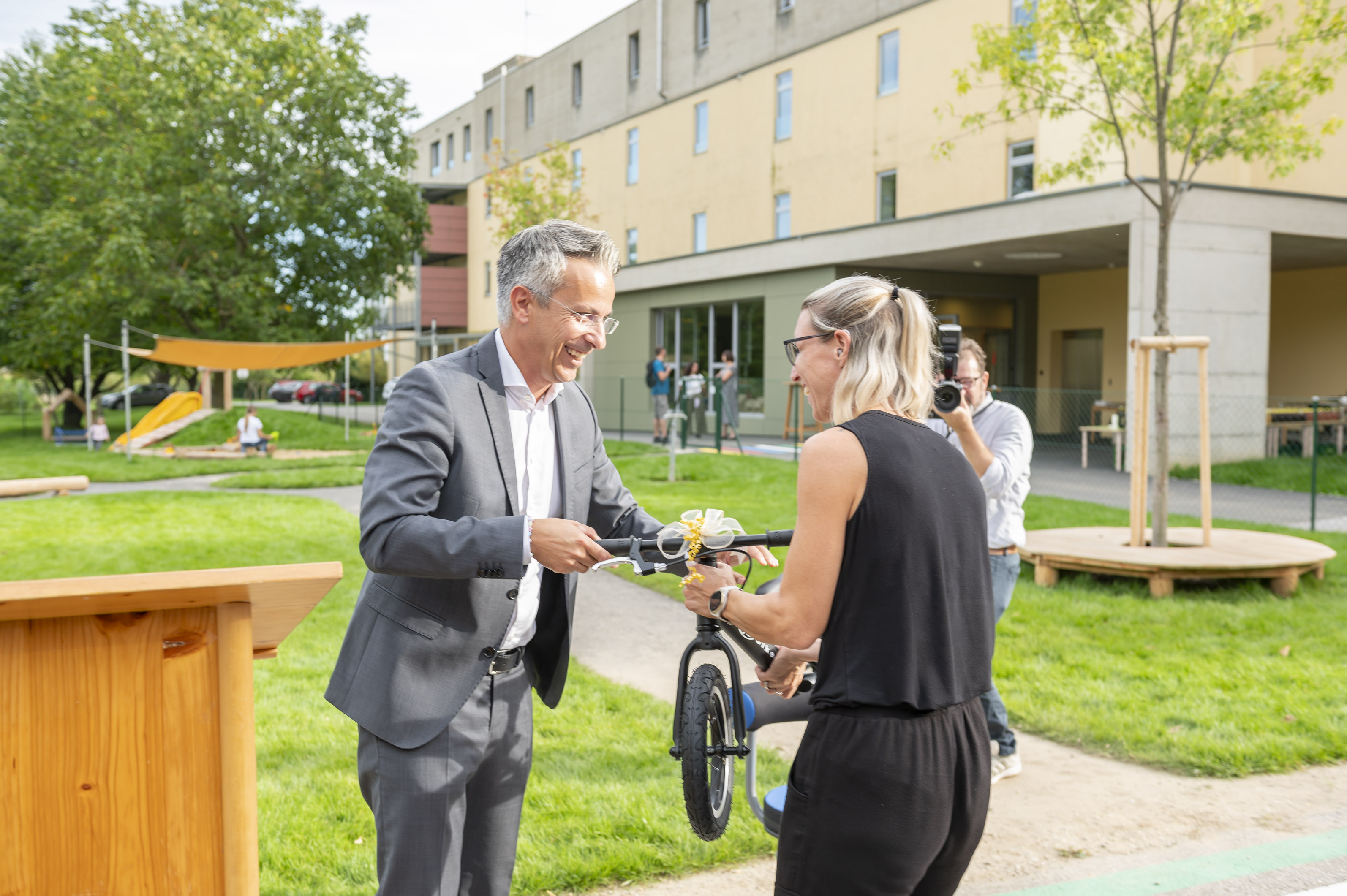 Bildungsstadtrat Kurt Hohensinner übergab der Leiterin des Kindergartens ein Laufrad.