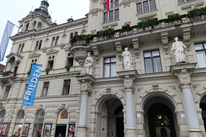 Eine Flagge mit der Aufschrift "Frieden" vor dem Grazer Rathaus