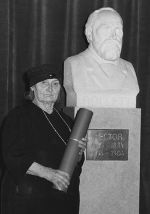 Oktavia Aigner-Rollett am Tage ihrer „Goldenen Promotion“ neben der Büste ihres Vaters Alexander Rollett in der Aula der Universität Graz (Bildausschnitt), Austro-Bilderdienst GmbH, 9. Dezember 1955, Fotografie